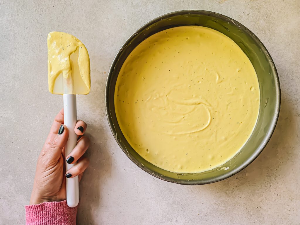 Hand med slev och en fylld cheesecake